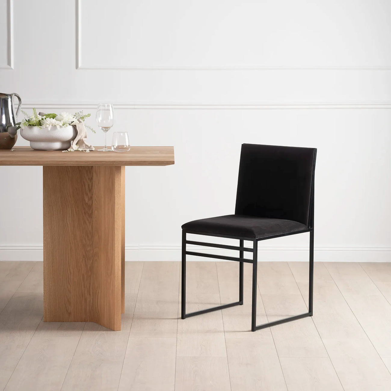 Isabell black velvet dining chair with matching frame in modern dining space, elegant design for a refined look.
