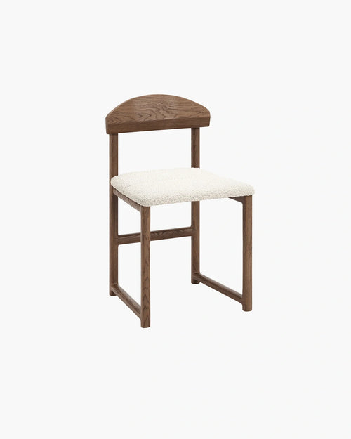 Karin dining chair with dark oak frame and ivory bouclé seat, showcasing modern design with rich wood and soft texture.