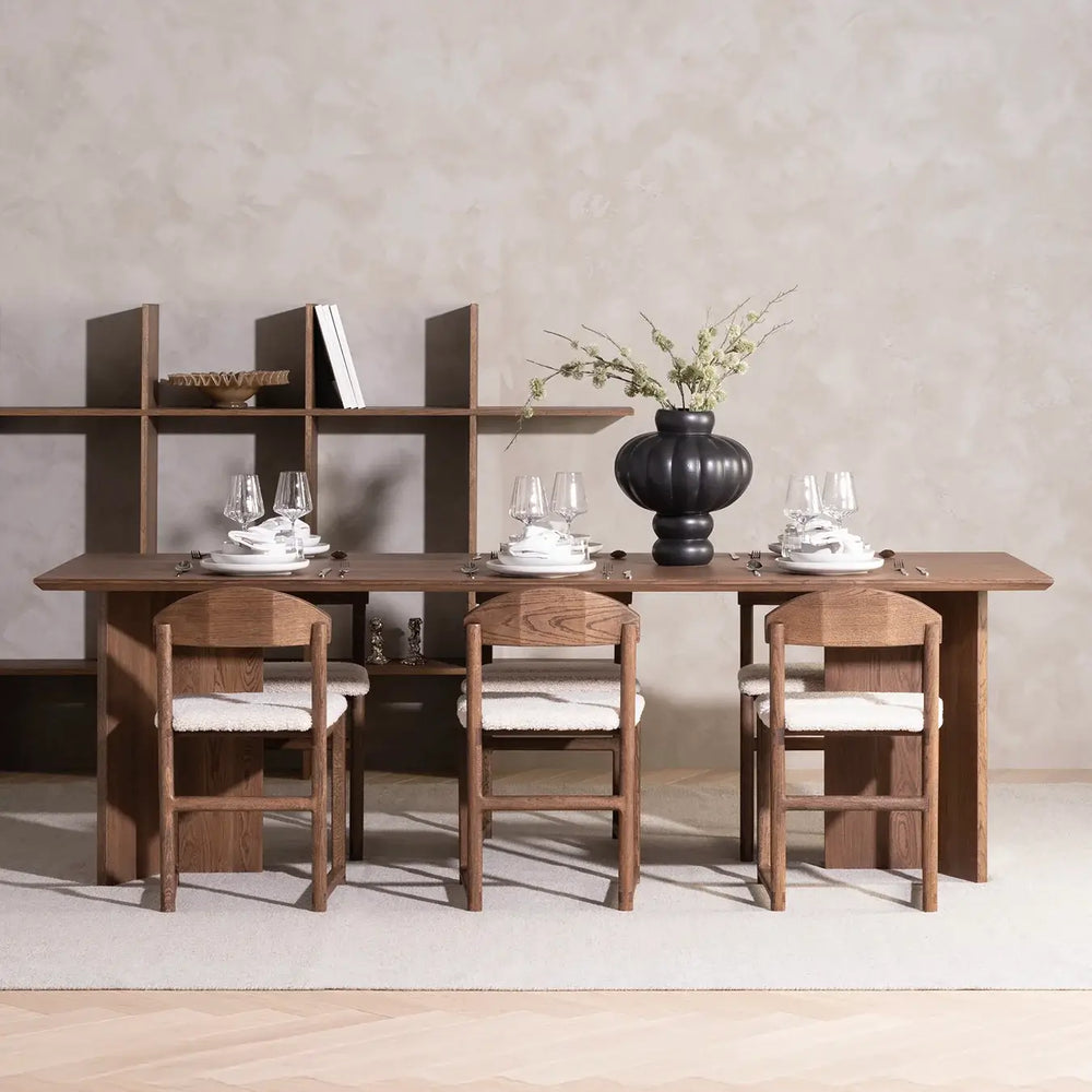 Dining chair Karin in dark oak with ivory bouclé on a dining table setting, showcasing modern design.
