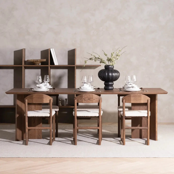 Dining chair Karin in dark oak with ivory bouclé on a dining table setting, showcasing modern design.