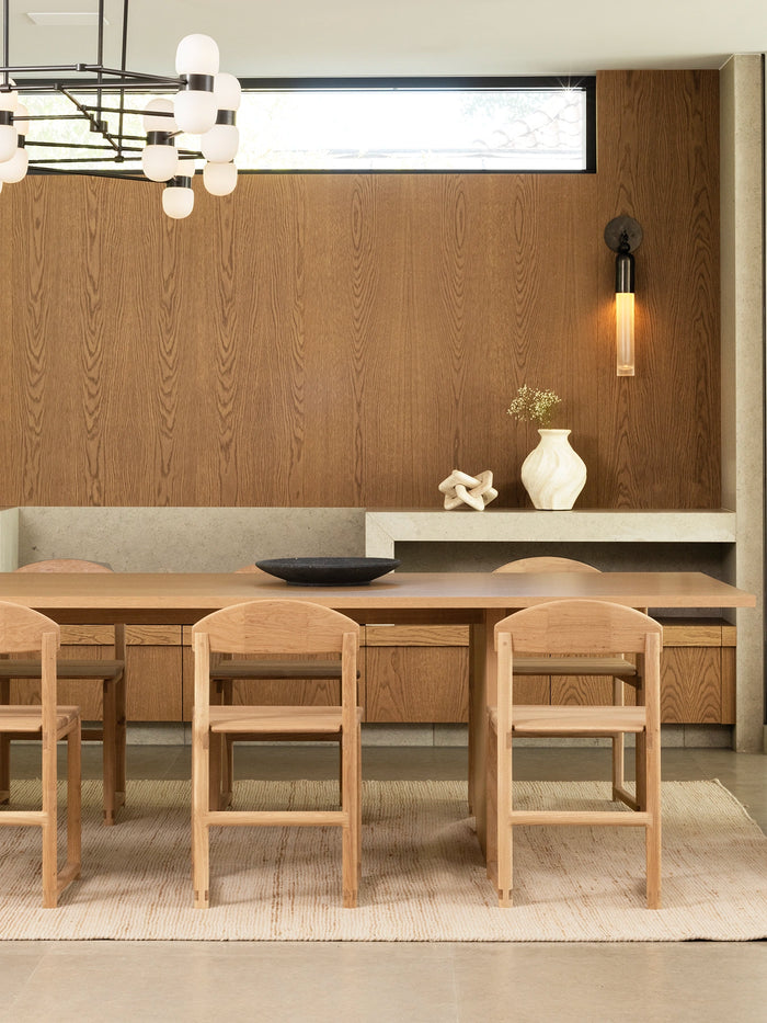 Karin dining chair in oak wood frame around a modern dining table in Scandinavian style interior.