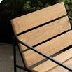 Close-up of Kenny Lounge Chair by by Crea, showing teak wood slats and black steel frame. Handmade designer outdoor furniture, part of the exclusive Scandinavian furniture collection.