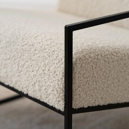 Close-up of ivory bouclé texture on Kent armchair with black frame, showcasing Nordic minimalism and comfort.