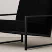 Minimalist black oak armchair with a black bouclé seat, showcasing modern design and relaxed support.