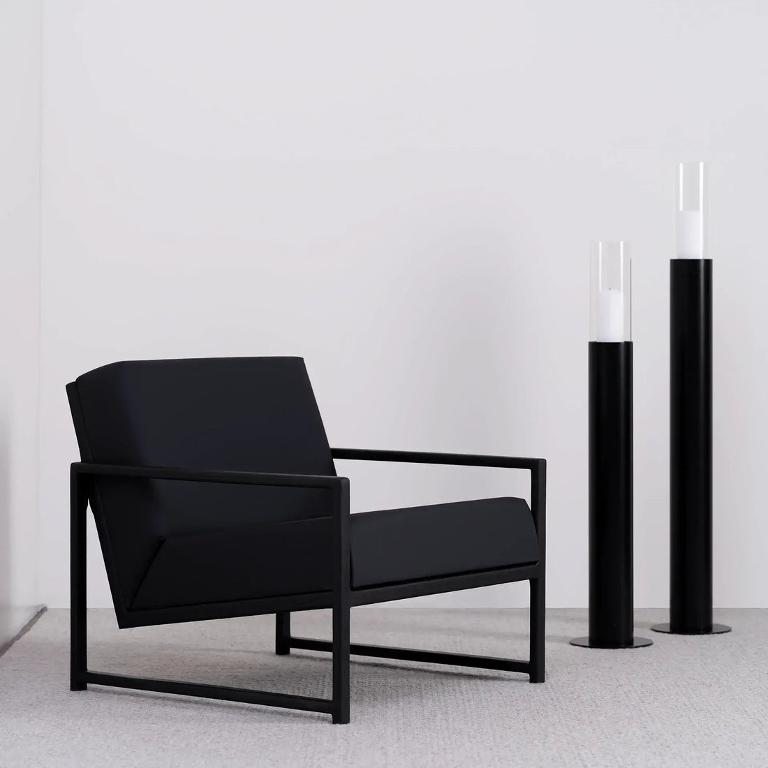 Armchair Einar – Black Oak Frame – Jade Black Leather Cushion, modern black armchair in a minimalist setting.