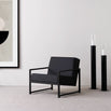 Black oak armchair with jade black leather seat, showcasing sleek Scandinavian design in a modern interior.