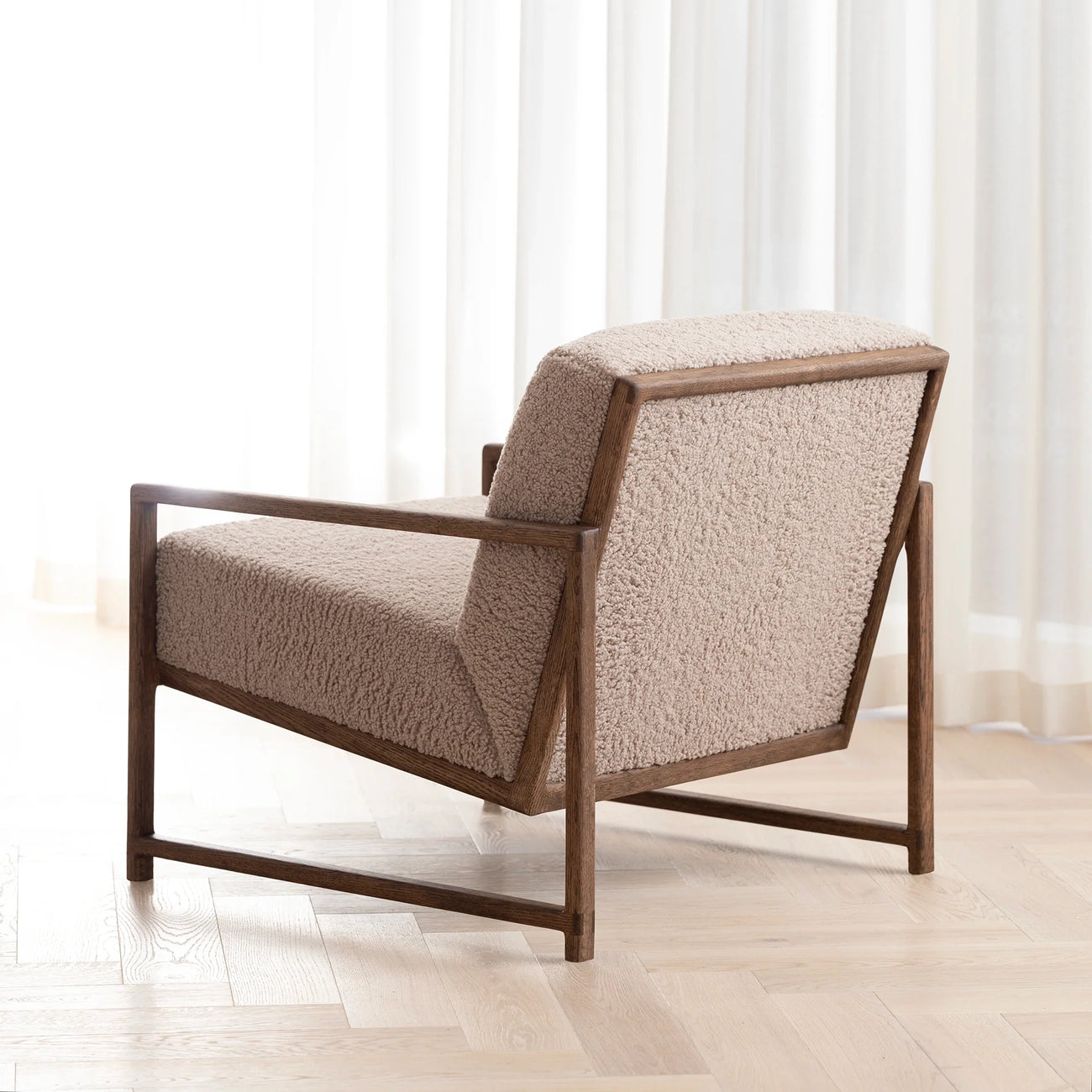 Kent dark oak armchair with greige bouclé upholstery, ideal for adding texture to neutral interiors.
