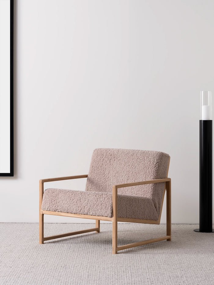 Armchair Einar with oak frame and greige bouclé cushion in a modern living space