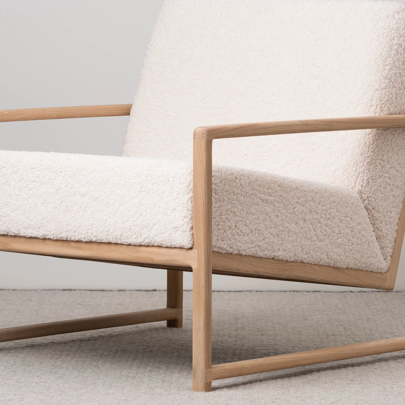 Kent oak armchair with ivory bouclé upholstery, perfect for modern Scandinavian interiors and relaxed living spaces.