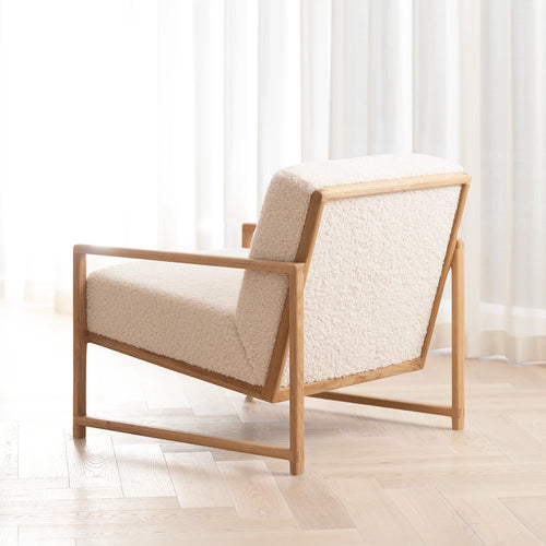 Kent oak armchair with ivory bouclé, featuring a solid wood frame and angled arms for modern Scandinavian-style living.