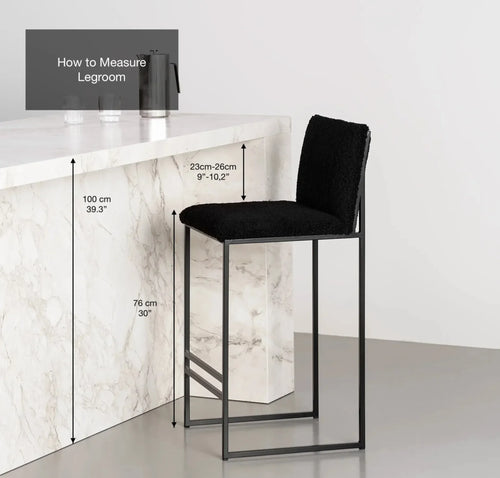Black bar stool with measurements on a white marble countertop