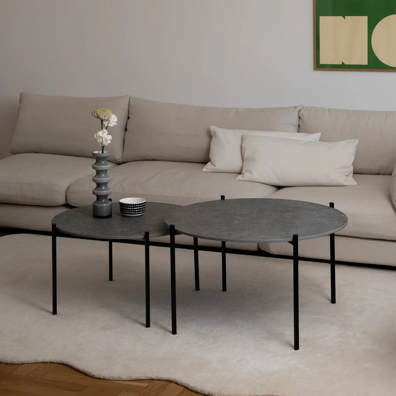 Leo Coffee Table 2-set by by Crea with Grafite Dekton tops and black steel frames, styled in a contemporary Scandinavian living room with a ceramic vase, patterned bowl, and cream modular sofa. Custom handmade coffee tables made in Sweden.