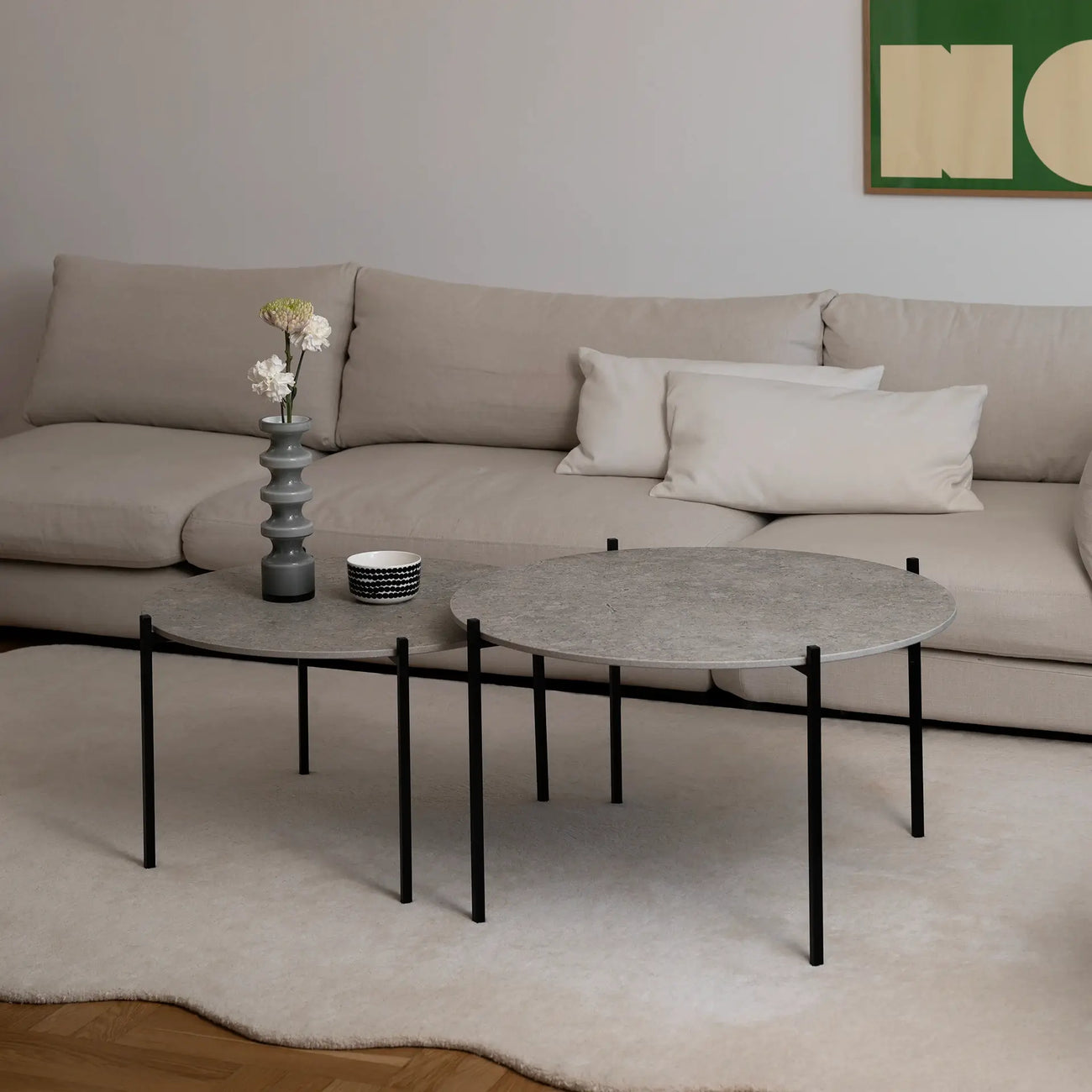 Leo Coffee Table 2-set by by Crea with Grigio Dekton tops and black steel frames, styled in a Scandinavian living room with ceramic vase, patterned bowl, and cream corner sofa. Handmade designer coffee tables for modern interiors.