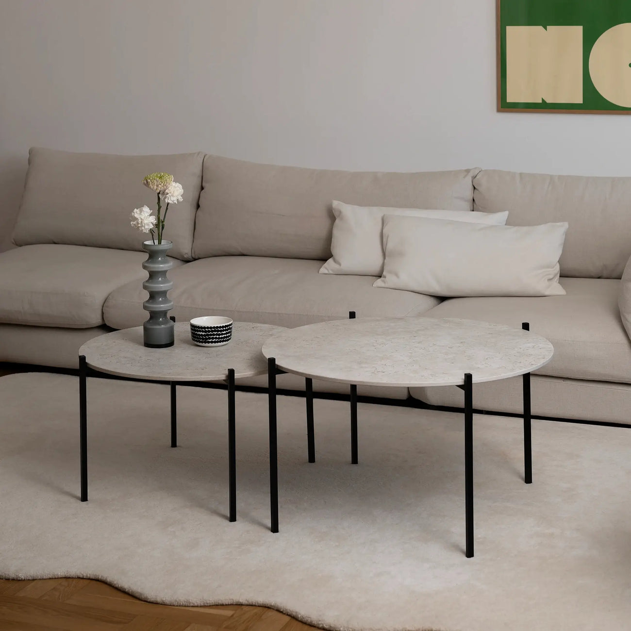 Leo Coffee Table 2-set by by Crea with Sabbia Dekton tops and black steel frames, styled with sculptural vase and ceramics in a Scandinavian living room with a beige sectional and soft ivory rug. Handmade designer coffee tables for modern homes.