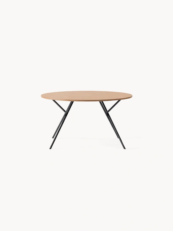 Round Dining Table Luna with a solid oak top on crossed black steel legs, seen from the front