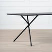 Melker Dining table in black oak with stylish cross legs, perfect for modern dining spaces.