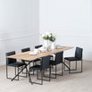 Melker Dining table in black with natural oak top, surrounded by sleek black chairs, showcasing modern elegance.