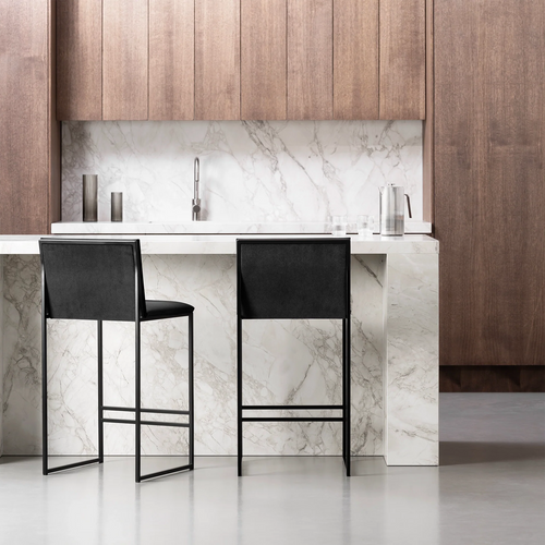 Black Philip bar stools with black velvet seats at a modern marble kitchen island, showcasing contemporary design and comfort.