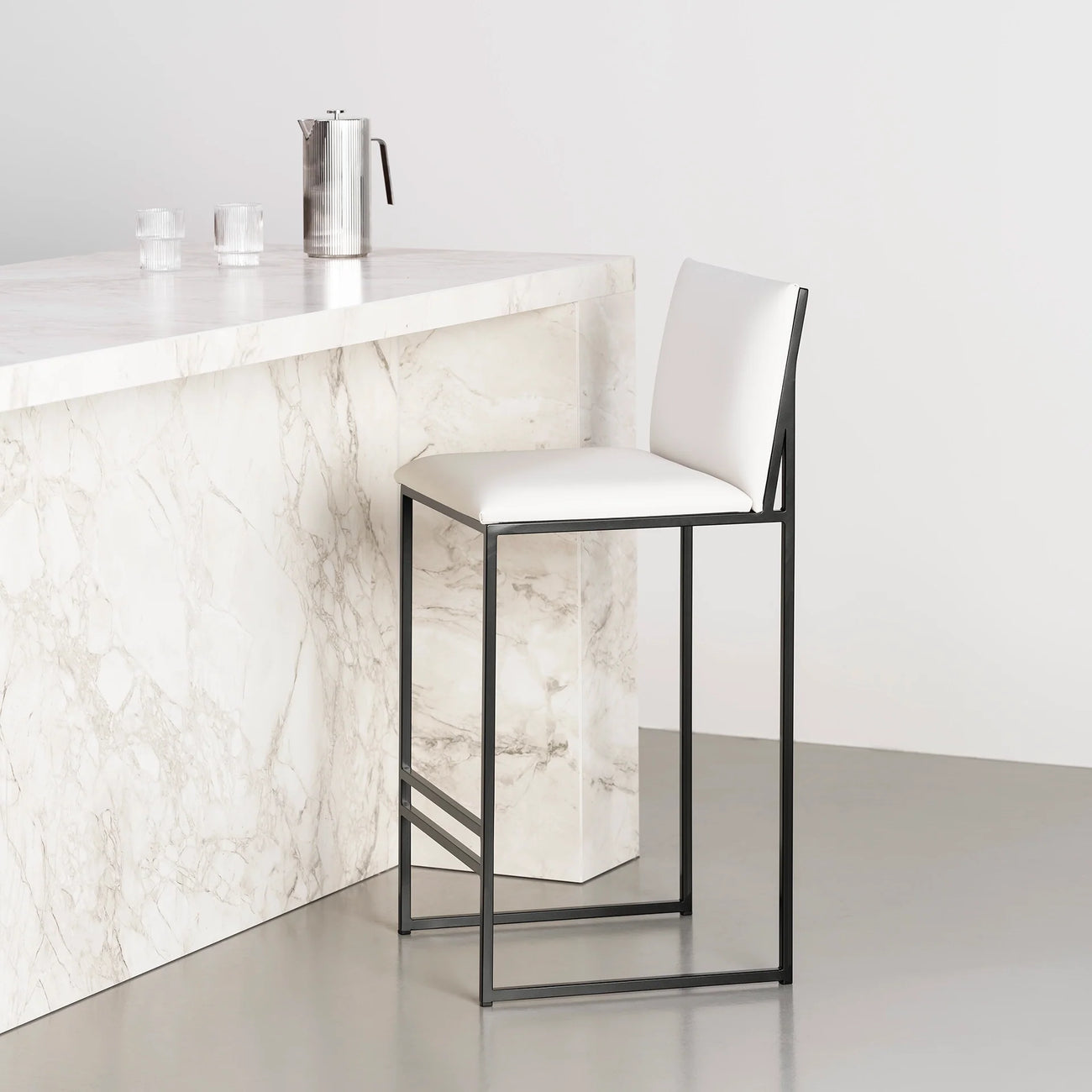 Philip bar stool with black frame and ivory leather seat, perfect for modern interiors, featuring a sleek silhouette.