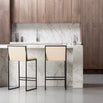 Philip bar stools in black frame and sand leather seat against a modern kitchen marble countertop.