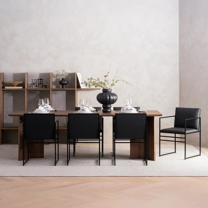 Elegant dining room featuring Sella dining chair in black leather with a modern wooden table setup.