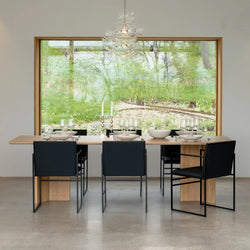 Modern dining space featuring Sella dining chairs in black leather around a stylish wooden table.