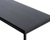 Close-up of corner detail on black oak sideboard top with sleek powder-coated steel frame, highlights natural wood texture and minimalist Scandinavian craftsmanship.