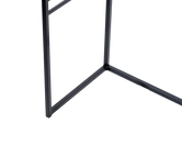 Detail of powder-coated black steel frame at the base of a minimalist sideboard, showcases clean lines and Scandinavian-inspired craftsmanship.