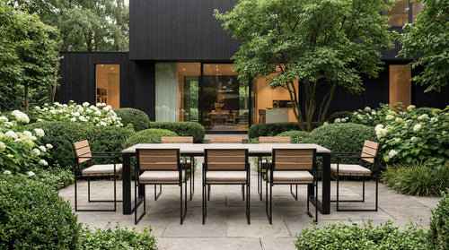 Outdoor dining area with table and chairs in a garden setting.