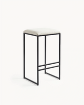 Bar stool with black metal frame and white cushioned seat on a white background