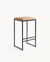 Bar stool with beige cushioned seat and black metal frame on a white background