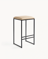 Bar stool with beige cushioned seat and black metal frame on a white background