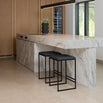 Svea bar stools in black leather at a modern kitchen island with marble countertops.