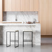 Svea bar stools in black frame with ivory bouclé seats, set against a modern marble kitchen countertop.