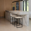 Svea black bar stools with sand leather seats at a modern kitchen island with marble countertop.