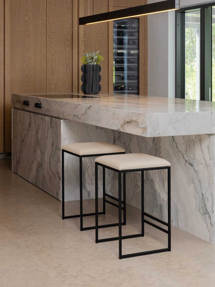 Bar Stool Svea – Black – Sand Leather at a modern kitchen island with marble countertop.