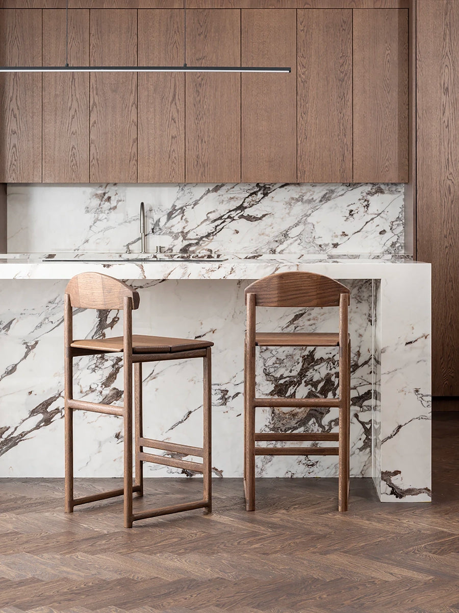 Oak Bar Stool Ted in dark oak with wood seat beside modern marble kitchen countertop