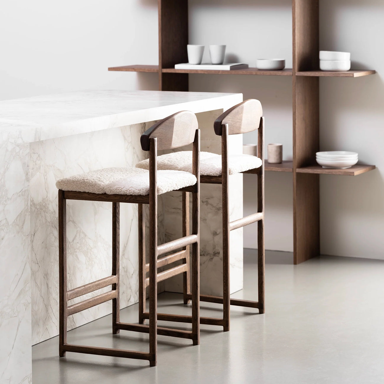 Dark oak bar stools with ivory bouclé seats, perfect for enhancing kitchens and bar areas with contrast and comfort.