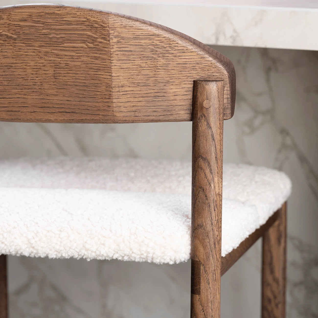 Dark oak bar stool with ivory bouclé seat, ideal for kitchens and bar areas, showcasing elegance and comfort.