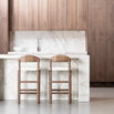 Elegant kitchen with two wooden bar stools and a marble countertop, showcasing modern design and style.