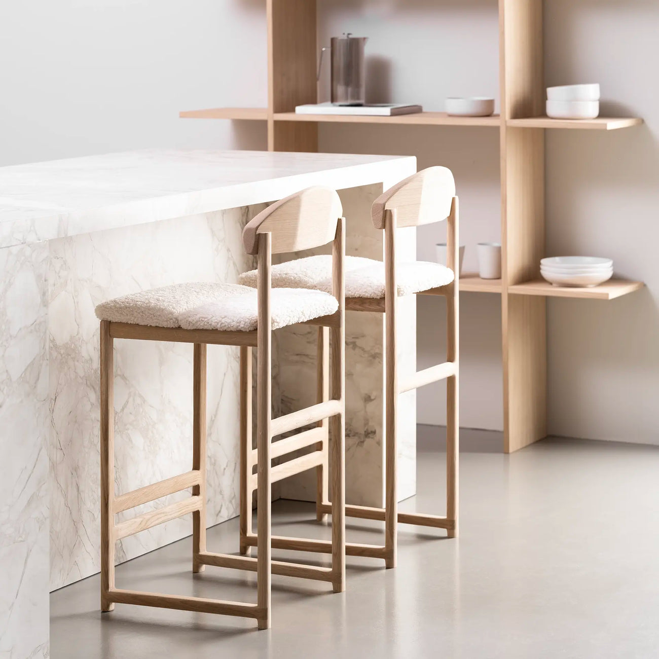 Ted bar stools with oak frame and ivory bouclé seats in modern kitchen setting, perfect for relaxed bar seating.