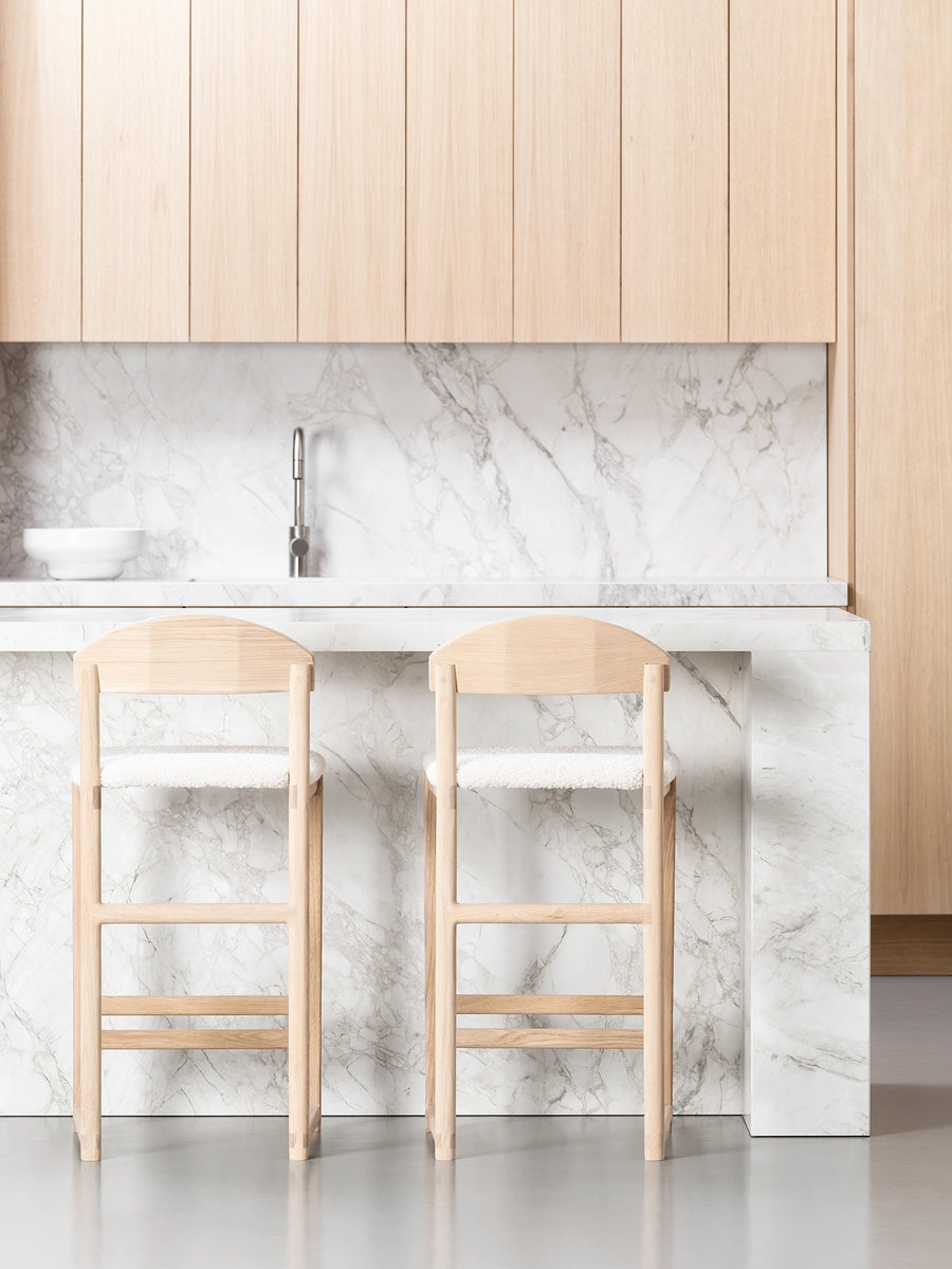 Oak Bar Stool in a modern kitchen with marble countertop and wooden cabinetry, perfect for relaxed seating.
