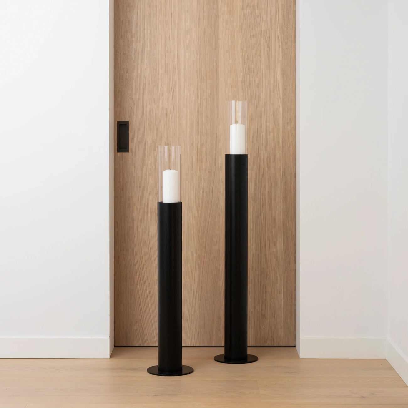 Thomas Floor candleholder set in black with light glass cylinders, perfect for adding elegance to any room.