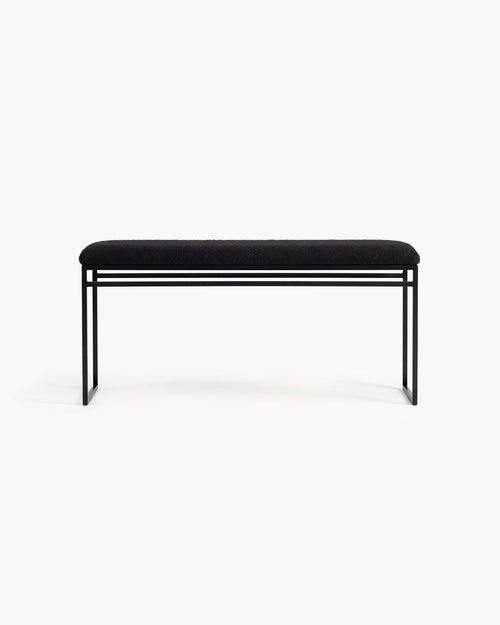Bench Wilma with a black frame and black bouclé cushion, showcasing a minimalist design.