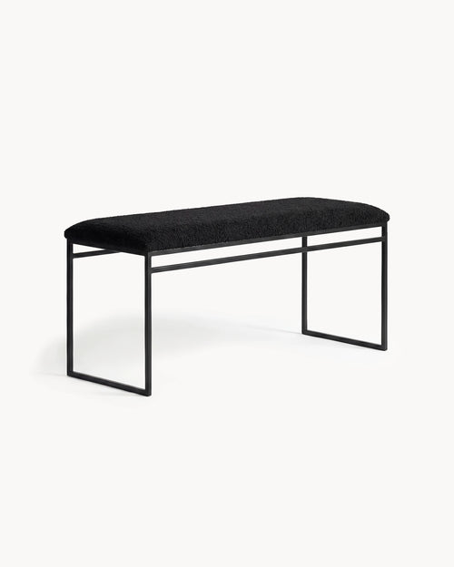 Bench Wilma with a black frame and black bouclé cushion for a minimalist look.