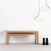 Oak Bench Alva with ivory bouclé cushion and solid oak frame against a white wall.